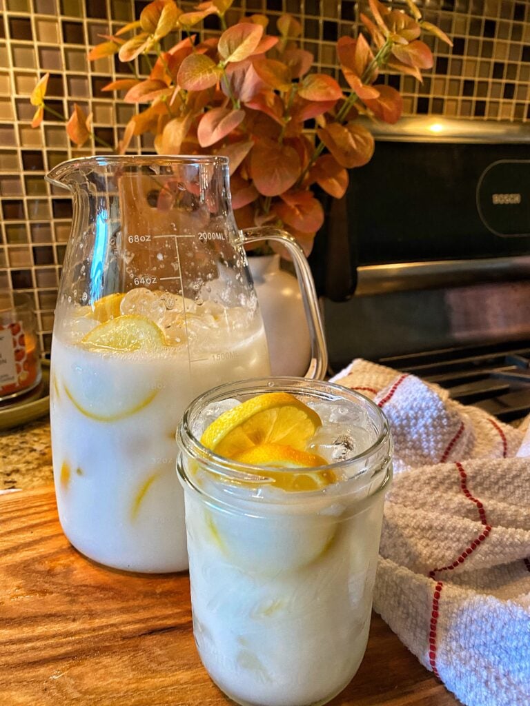 A pitcher and glass of white lemonade