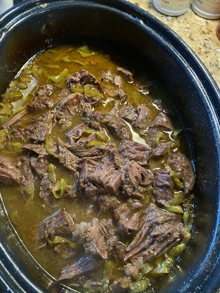 A slow cooker of Italian beef