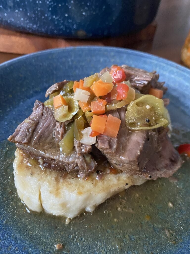 Slow cooked Italian beef with giadiniera on a bread dumpling