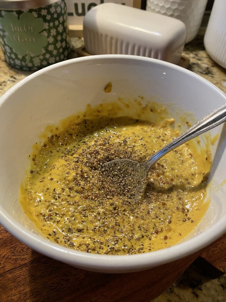 The mustard glaze being stirred in a bowl