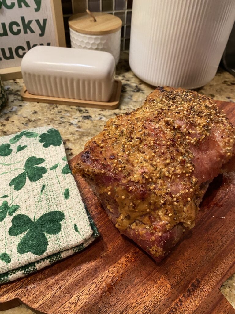 Oven baked corned beef on a cutting board before being sliced