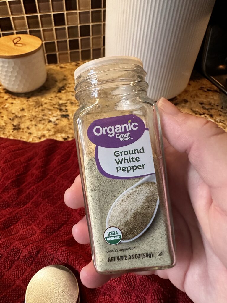 A shaker of ground white pepper