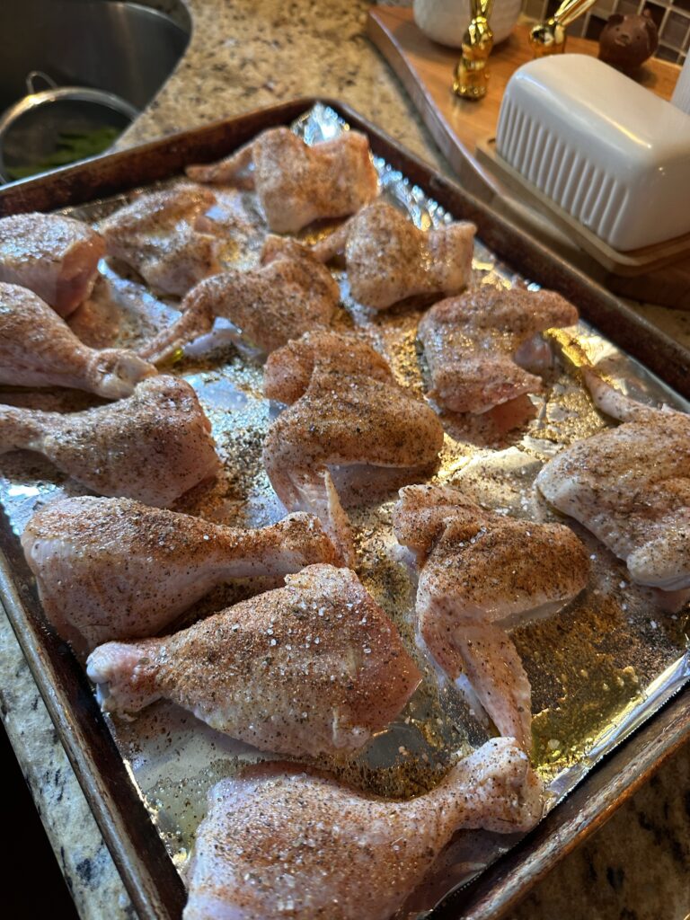 Raw seasoned chicken on a foil lined baking sheet