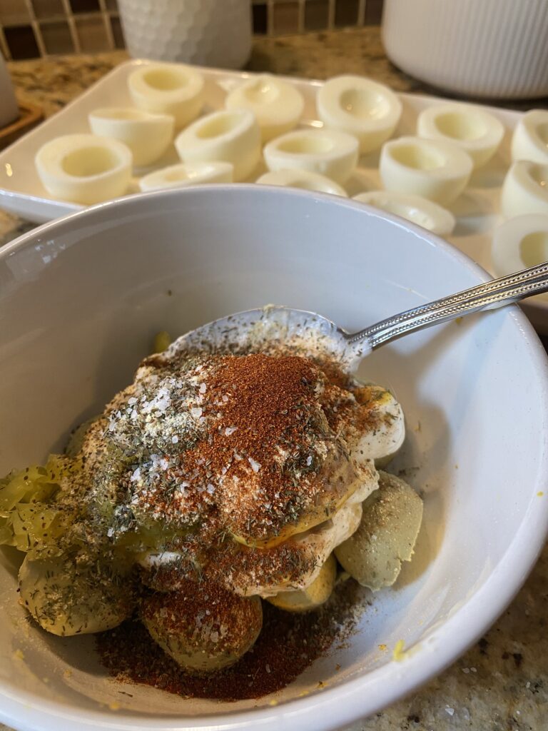 The deviled egg mixture being mixed with a spoon