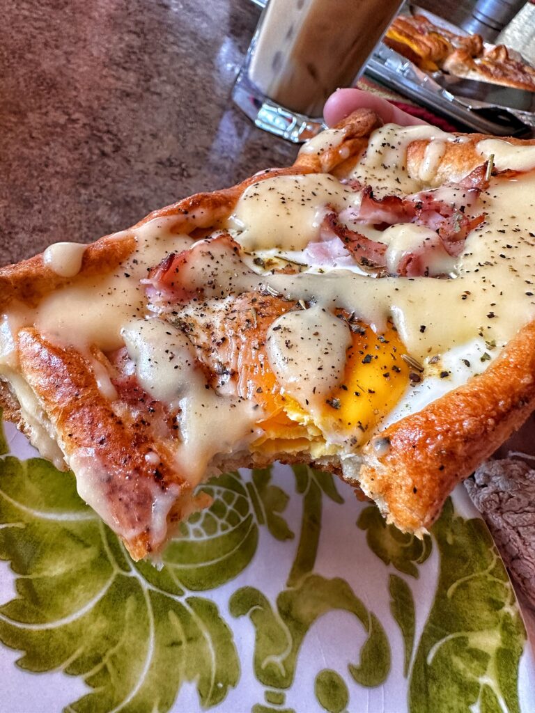 An eggs benedict pastry with a bite taken out of it