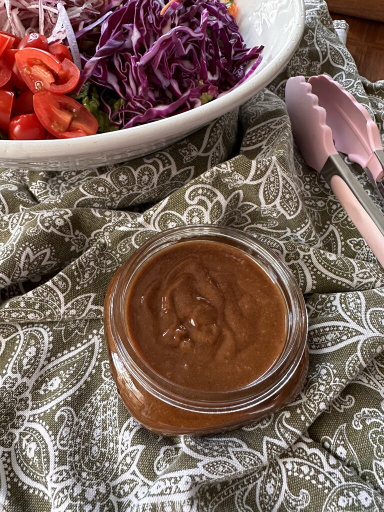 Peanut dressing on the side of Thai Crunch Salad