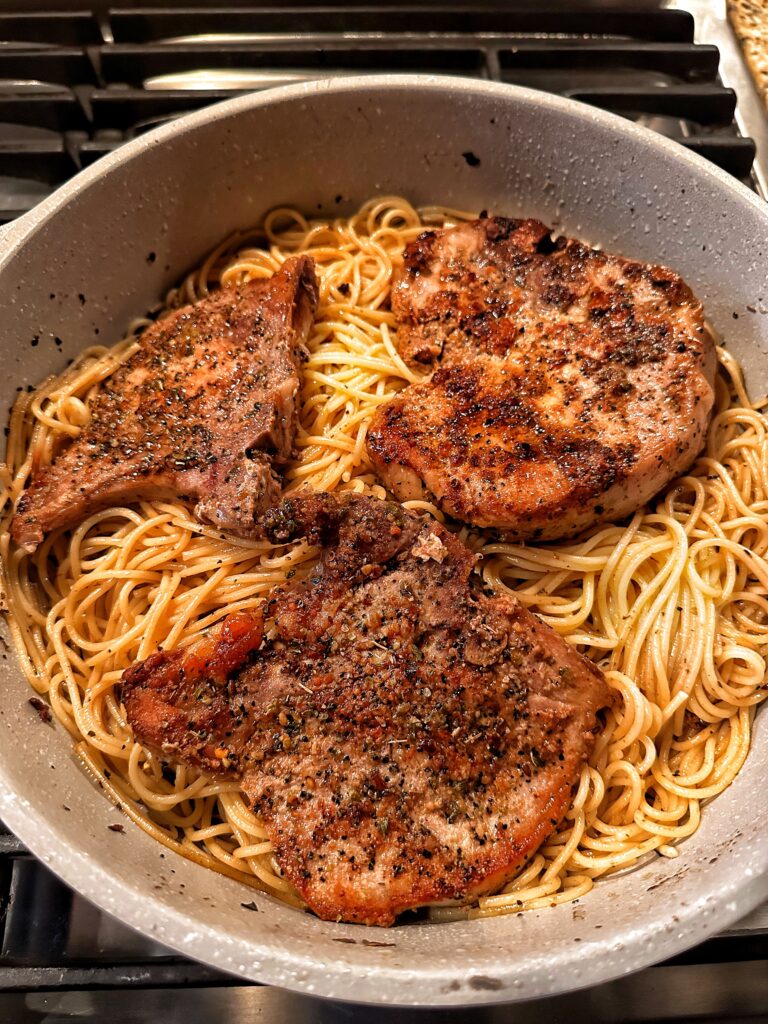 Pork chops and spaghetti in a pan
