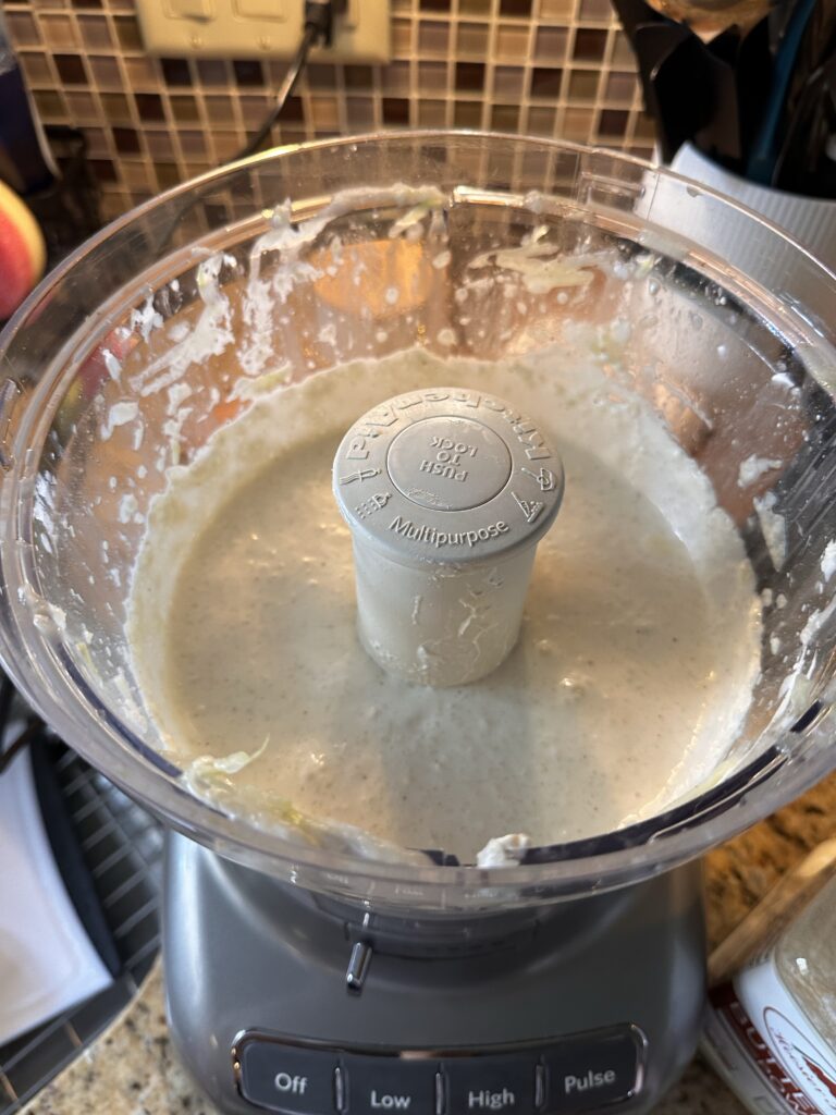 A food processor with white dip inside