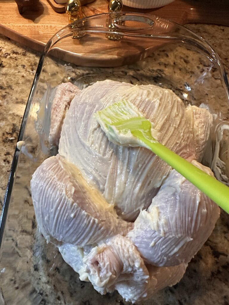 The chicken being brushed with mayo
