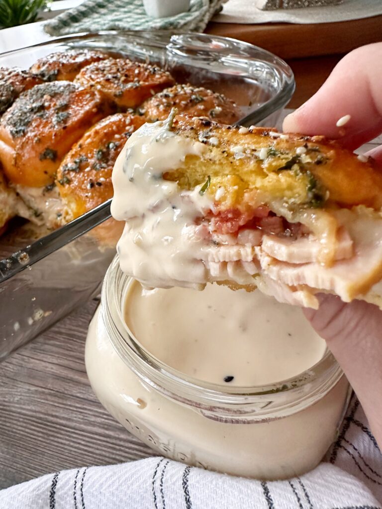 A hot brown slider dipped in white sauce