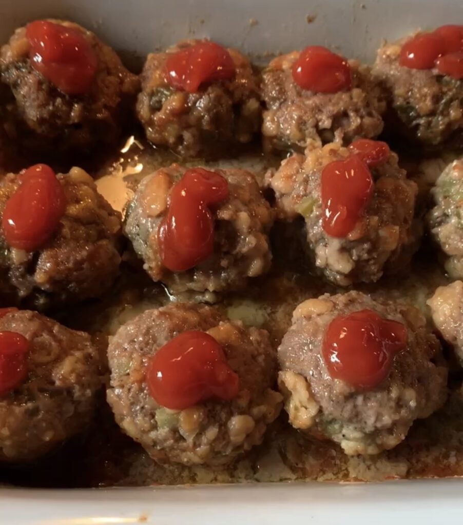 The meatballs molded into shape and topped with ketchup