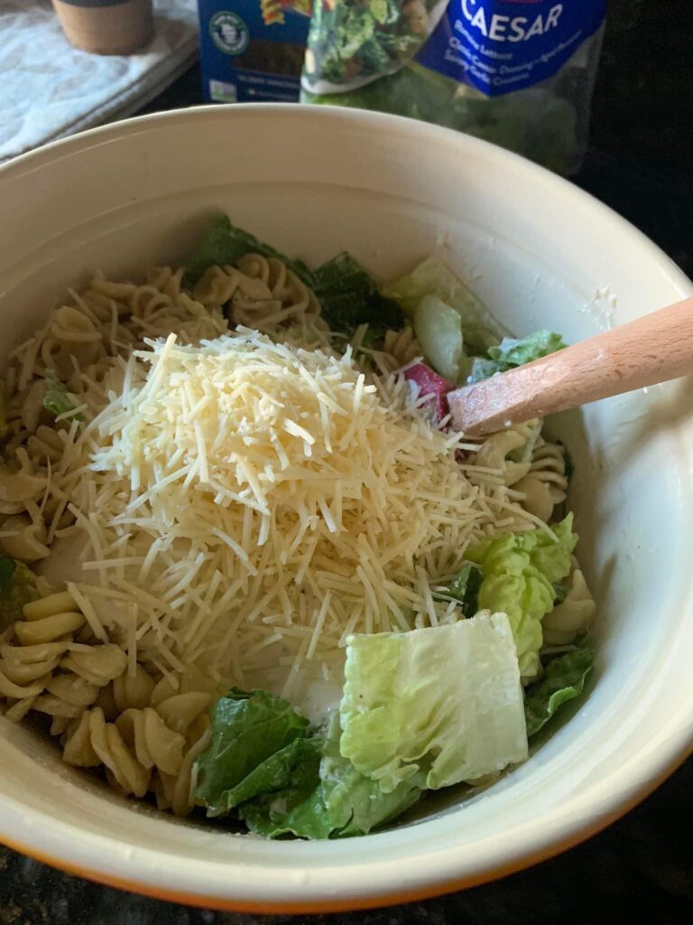 Shredded cheese on caesar pasta salad