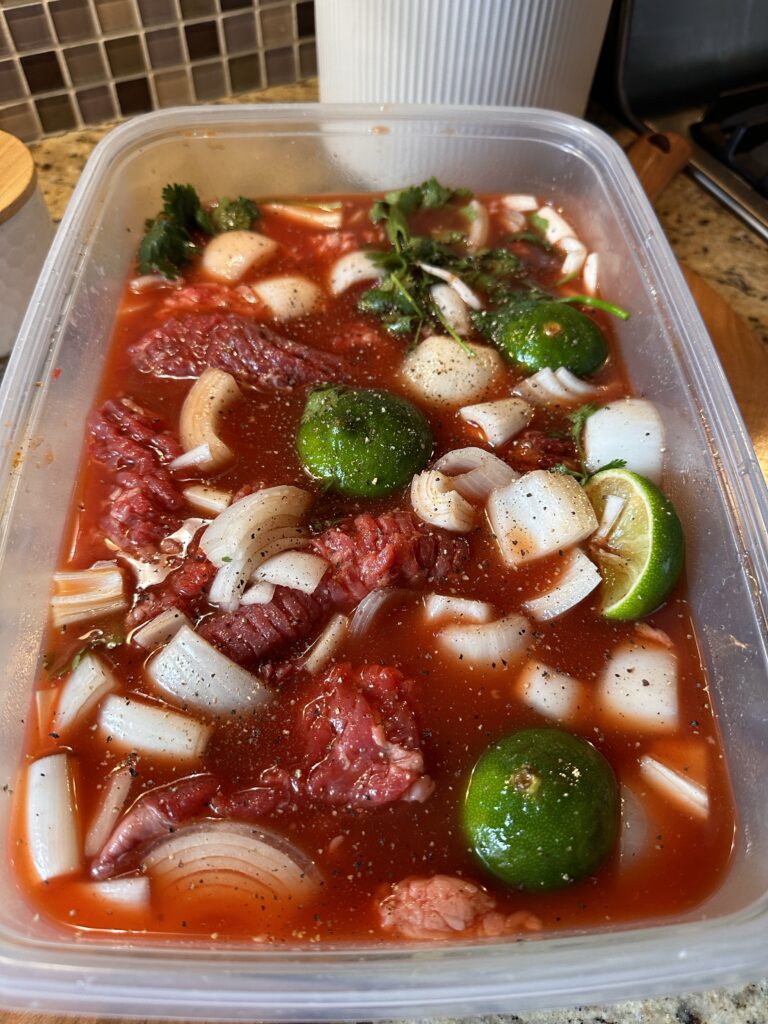 Steak marinating with onion and lime.