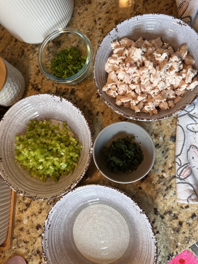 The components of the chicken salad, including celery, dill, and chicken