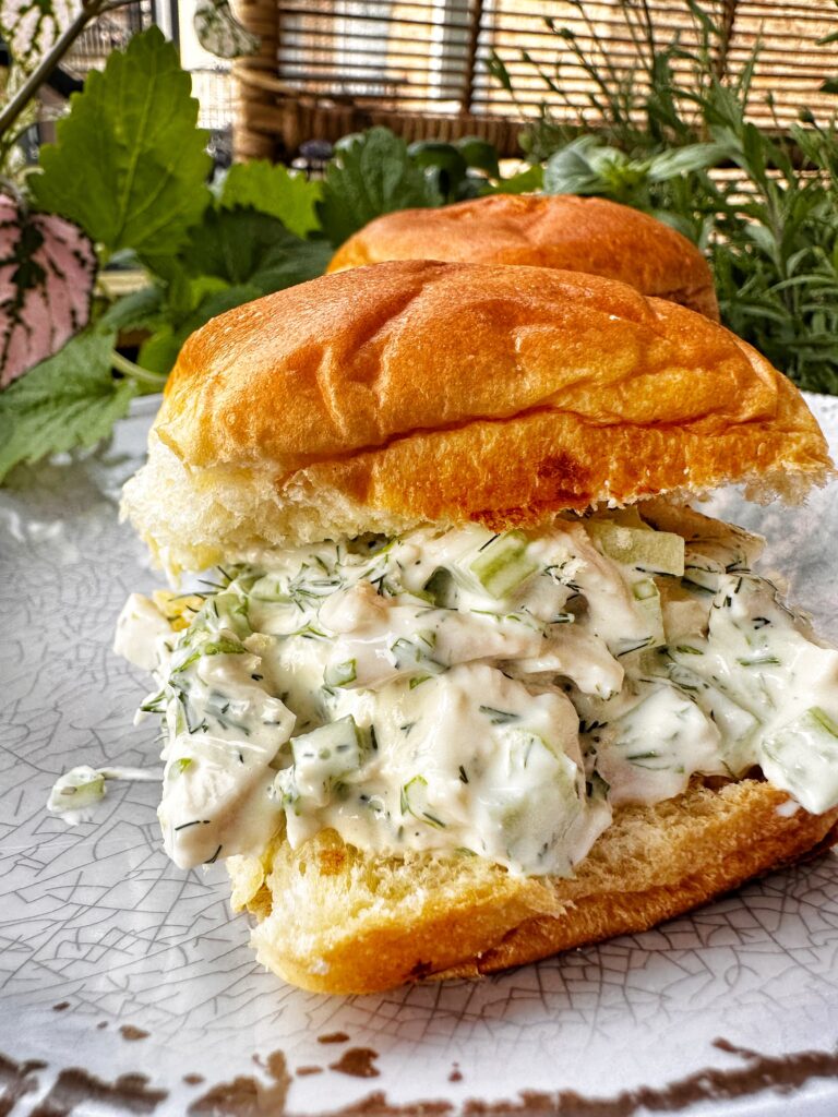 A close up of chicken salad on a roll