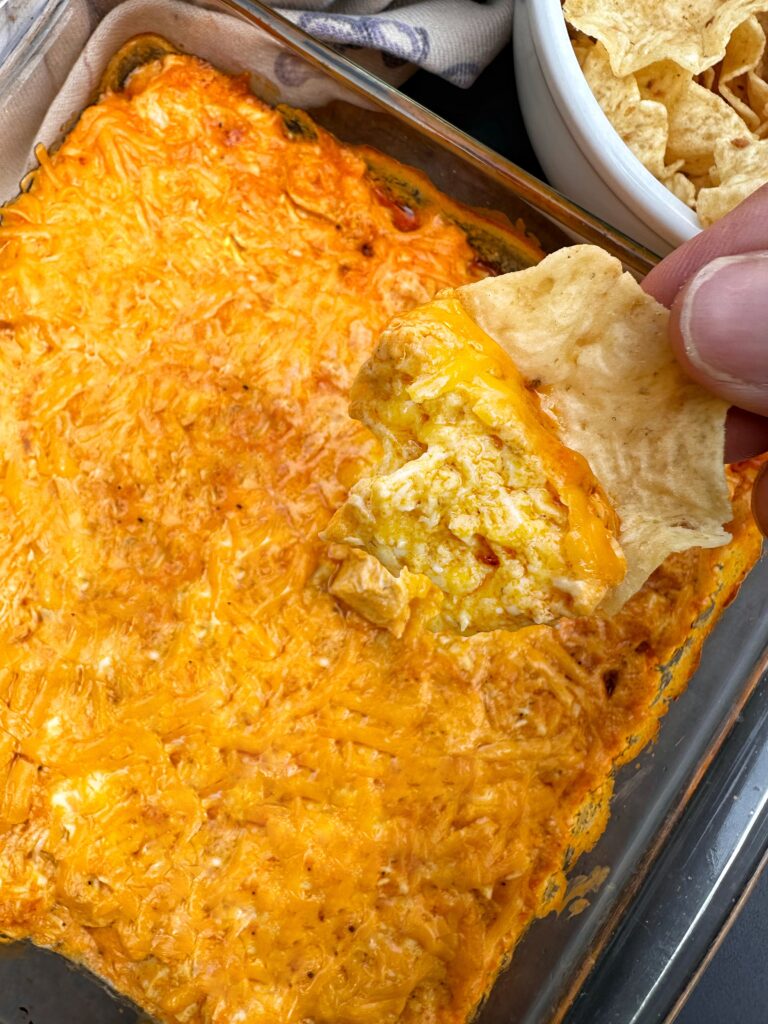 A corn chip being dipped into pickley buffalo chicken dip