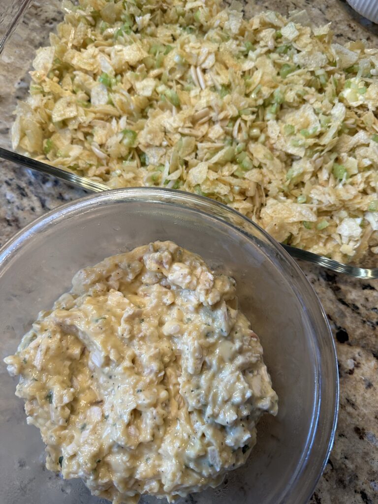 The potato chip base of the baked chicken salad in a glass baking dish