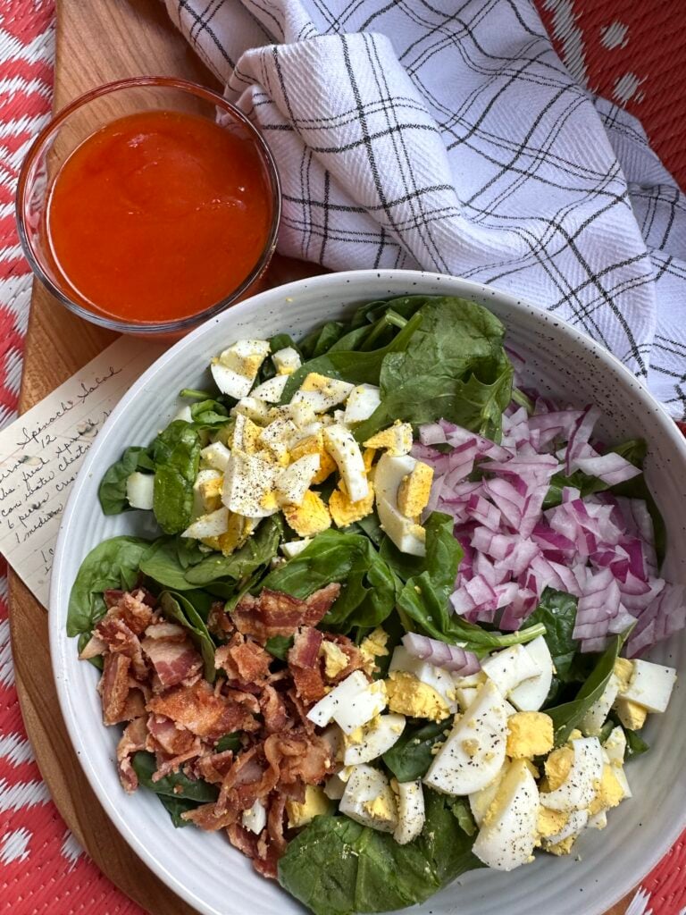 Spinach salad with eggs, onions, and bacon