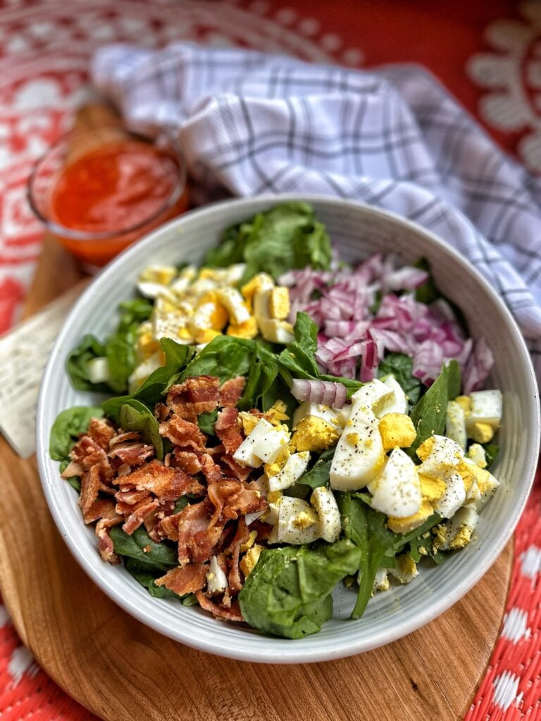 Spinach salad with eggs, onions, and bacon