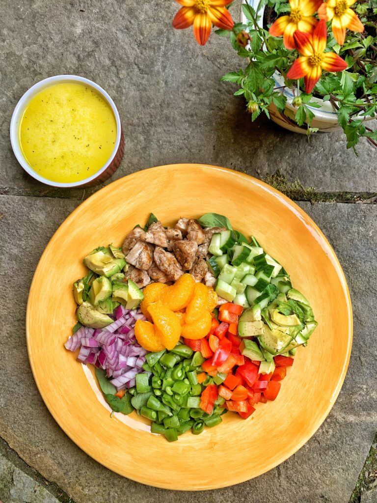 Poppy Seed Salad next to a cup of dressing