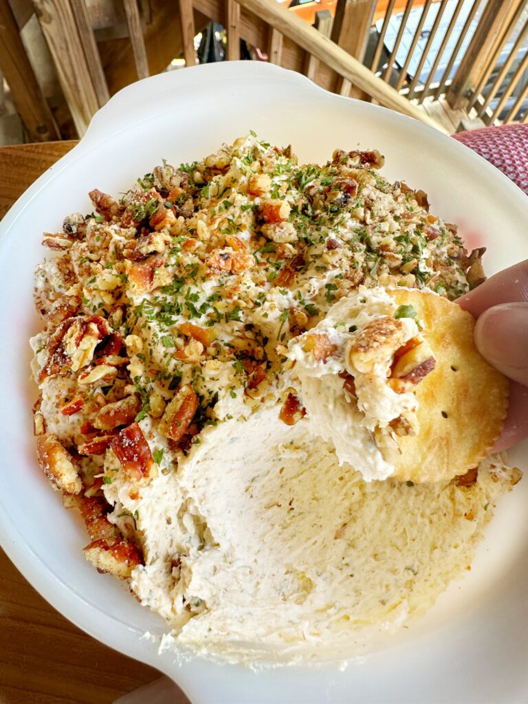 A Ritz cracker being dipped into chicken spread