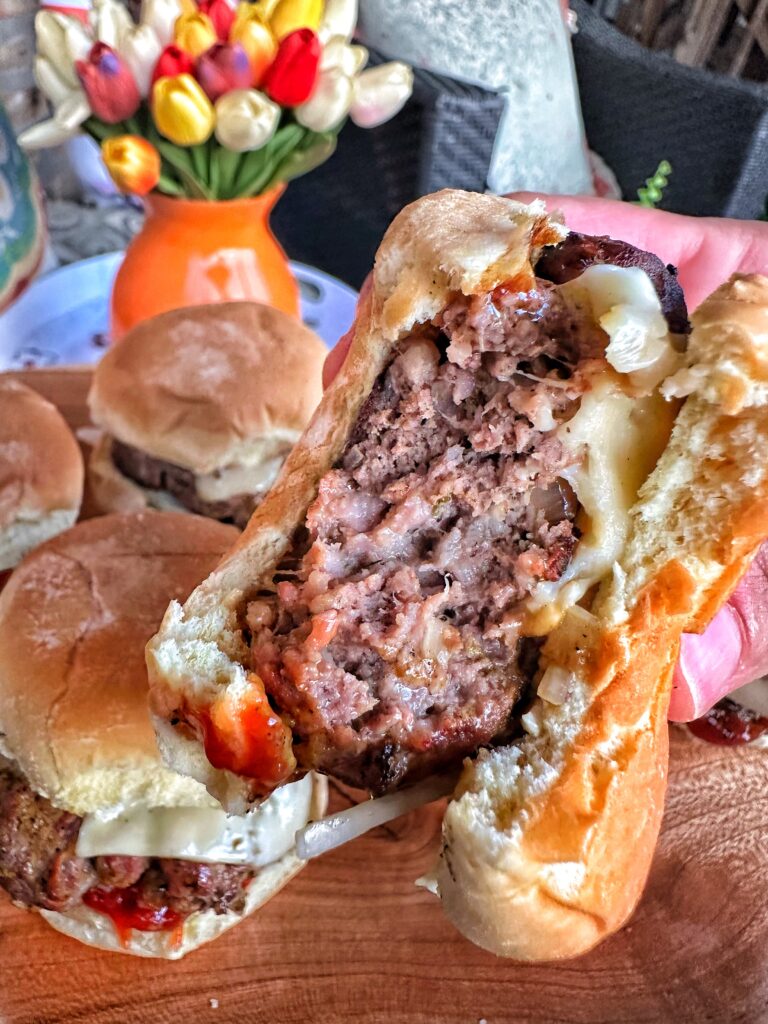A close up of a secret ingredient burger with a bite taken out of it