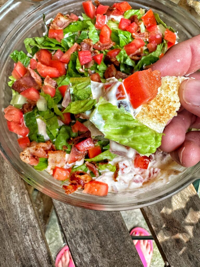 A toast point dipped in BLT dip