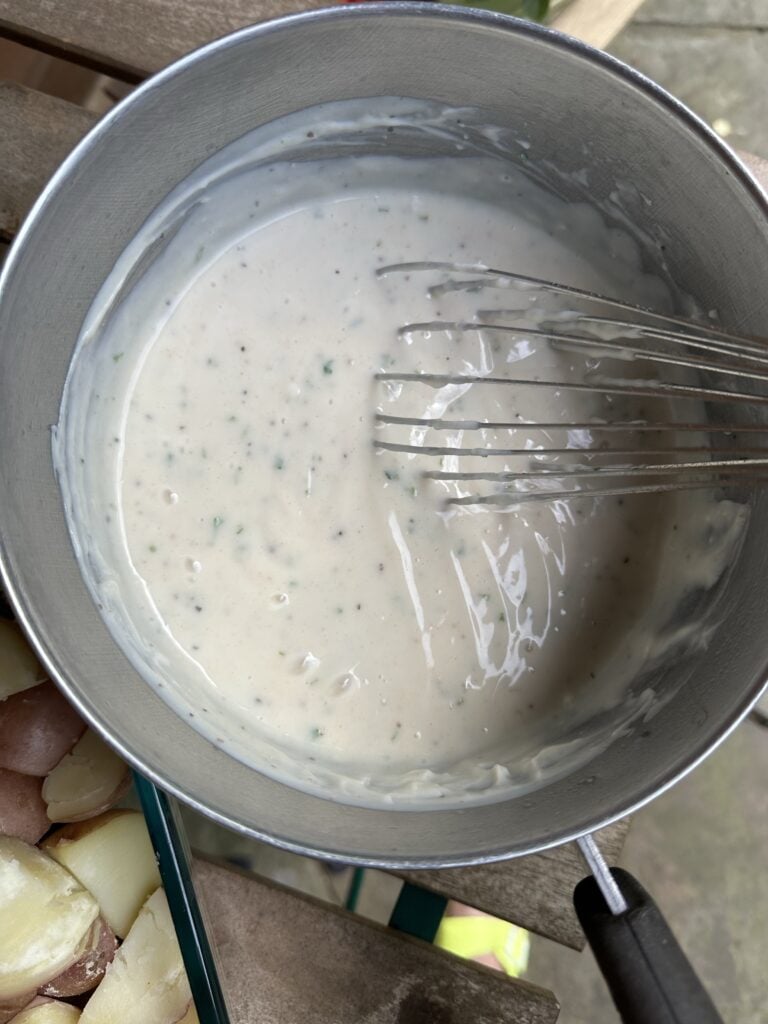 White sauce in a bowl with a whisk
