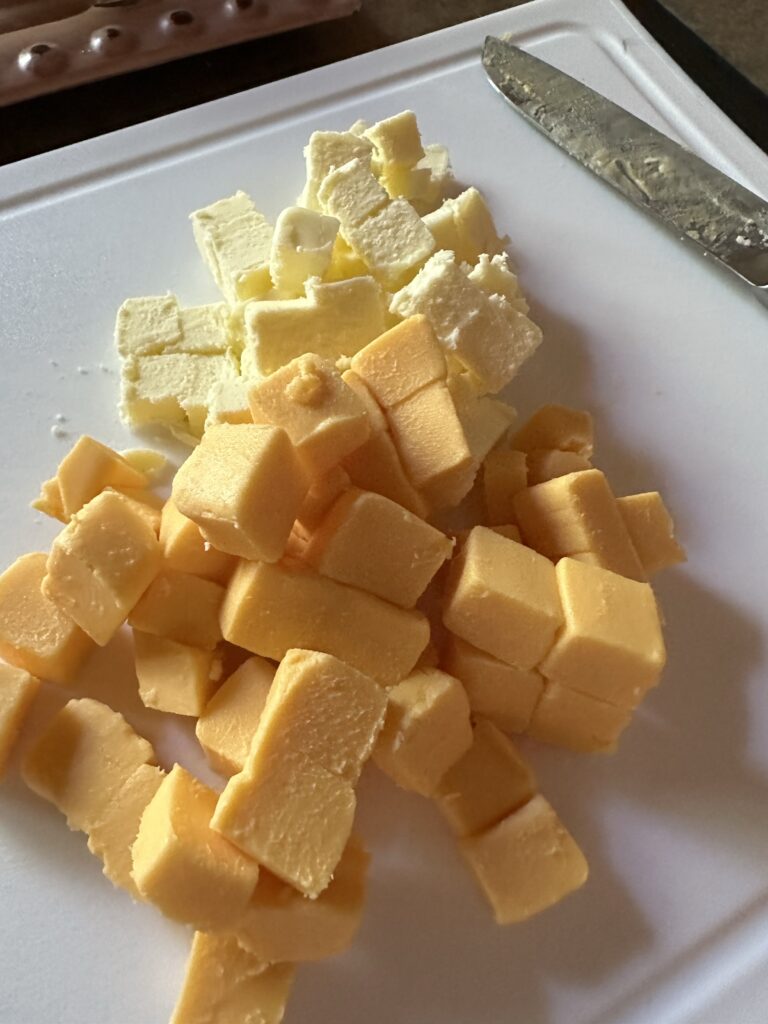 Cubes of cheese on a white cutting board