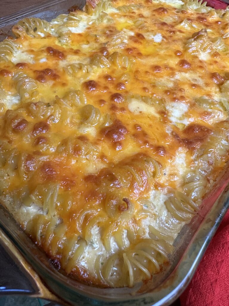 A close up of the finished mac and cheese in a glass baking dish