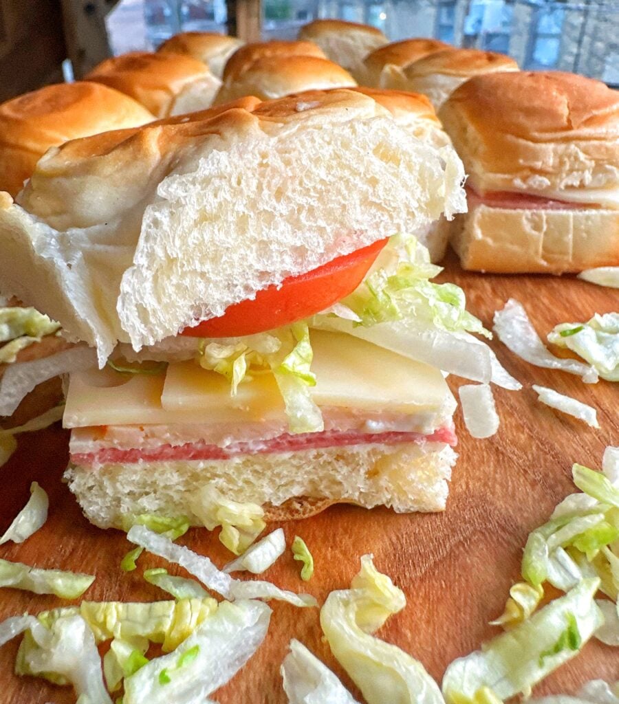 A boat bite sandwich with deli meat, cheese, lettuce, and tomato