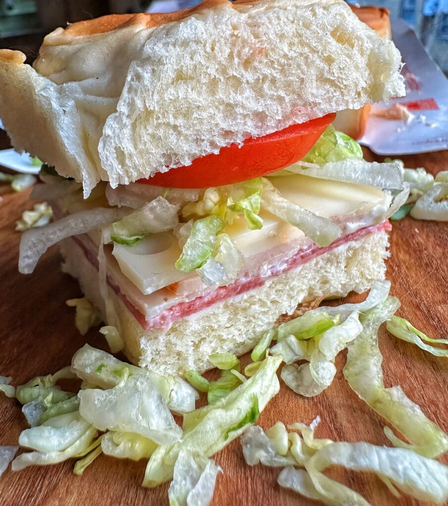 A close up of a finished boat bite sandwich on a wooden cutting board