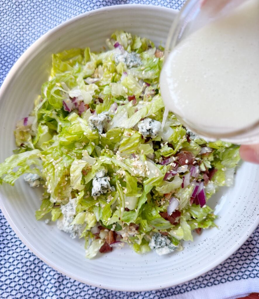 The dressing being poured over the salad