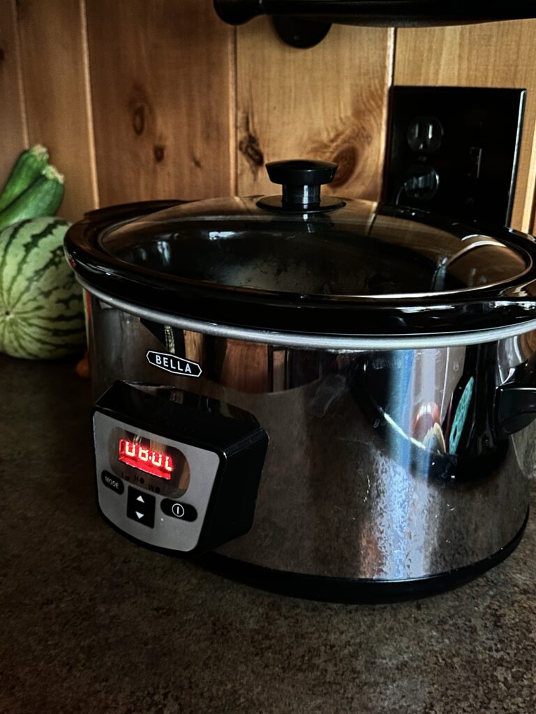 A slow cooker on a counter with the digital display 