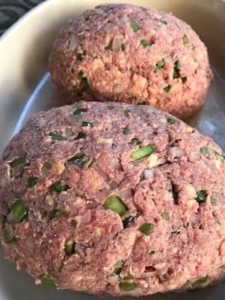 Two loafs of raw ground beef with minced onion and pepper
