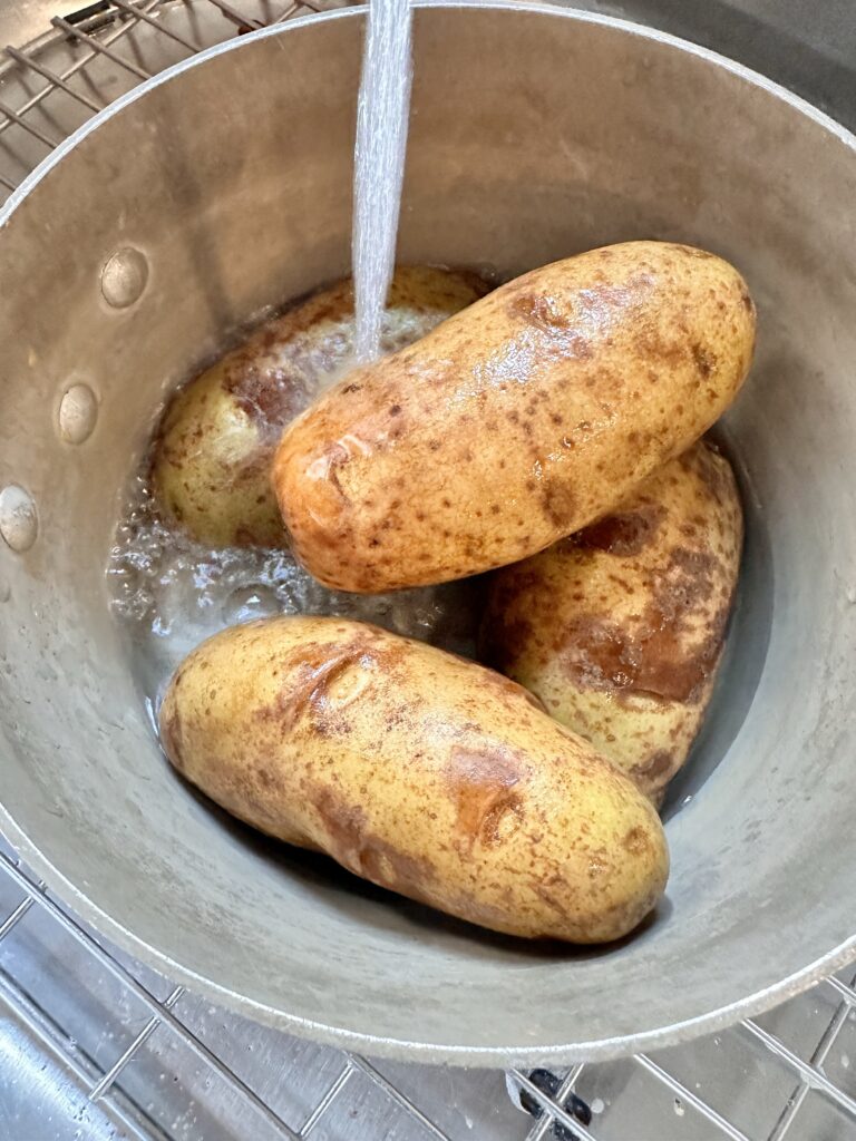 Potatoes being washed in a pot