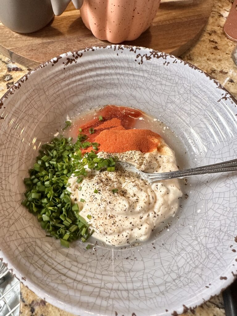 The ingredients for the sandwich sauce in a bowl with a spoon.
