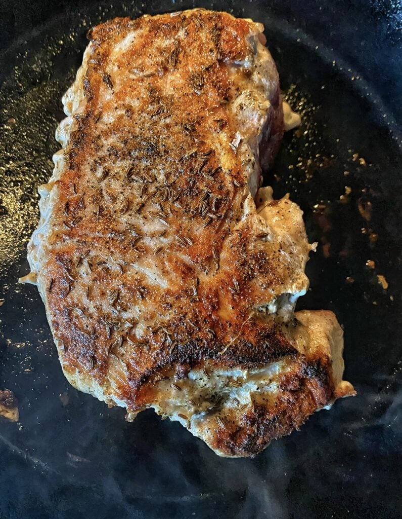 Pork cooking in a pan.