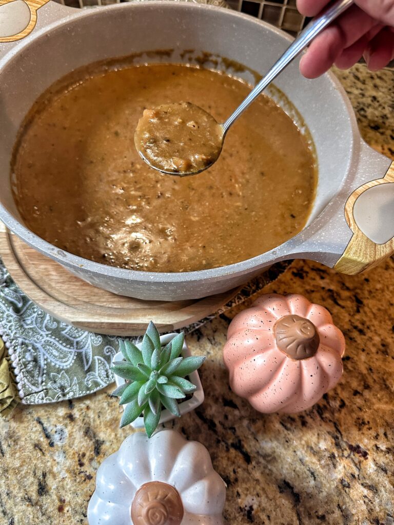 Turkey gravy in a spoon over a bowl with more gravy