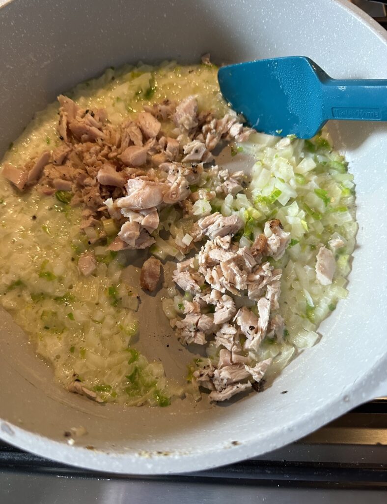 Turkey pieces, onions, and seasoning simmering in a pot
