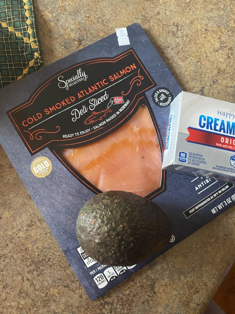 A package of cold smoked Atlantic salmon, an avocado, and a box of cream cheese.