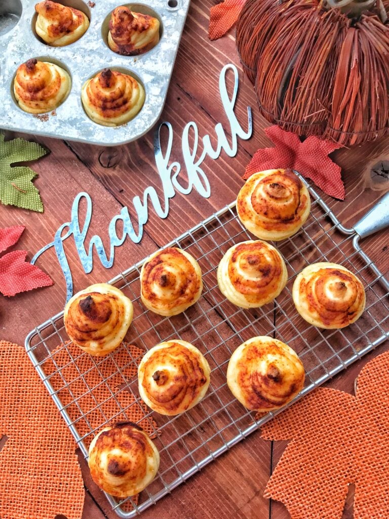 Completed potato bombs on a mesh tray on top of a table with Thanksgiving decorations
