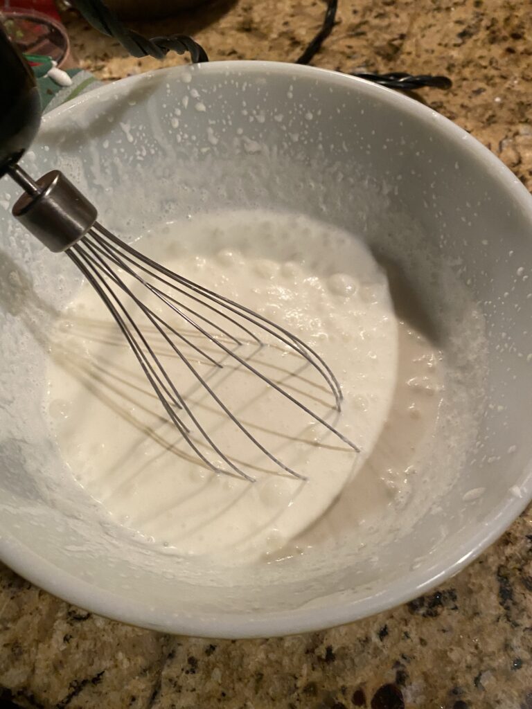 Heavy cream in a bowl with a whisk