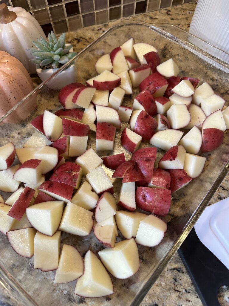 Sliced, raw red potatoes in a glass baking dish