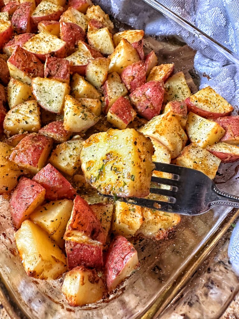 A roasted herbed potato on a fork