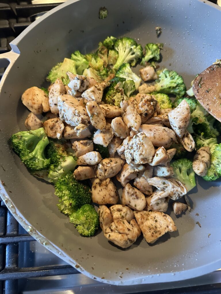 Cooked chicken and broccoli in a skillet