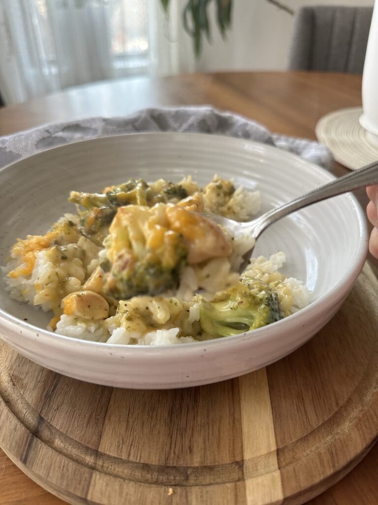 A spoon of creamy cheesy broccoli and rice