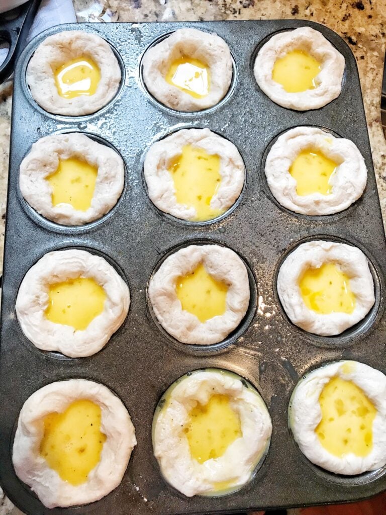 Egg you in raw biscuit dough in a muffin tin