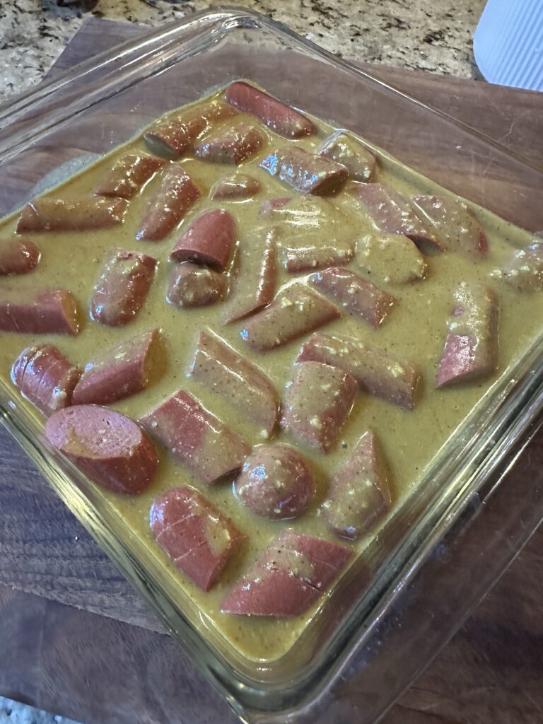 Cut sausages marinating in sauce