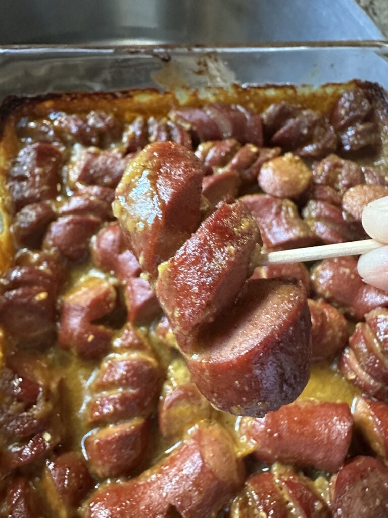 A tangy mustard sausage bite on a tooth pick